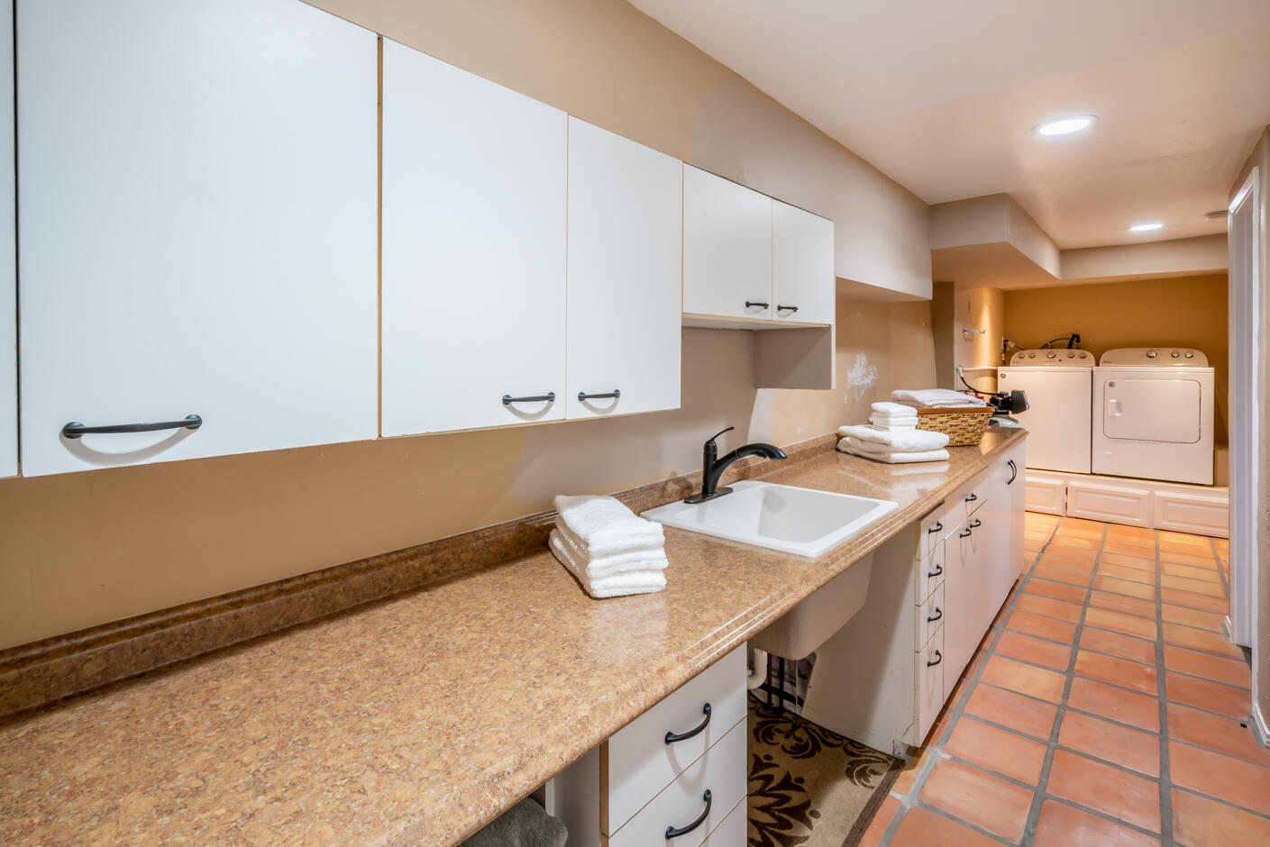 511 Drexel Drive Santa Barbara, CA 93103 - Photo 24 of 27 a kitchen with a sink dishwasher stove and white cabinets