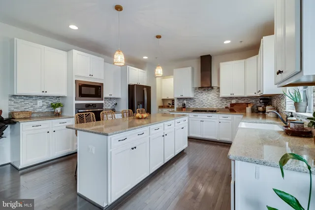 a kitchen with stainless steel appliances granite countertop a sink a stove and cabinets