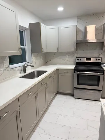 a kitchen with stainless steel appliances granite countertop a sink and a stove