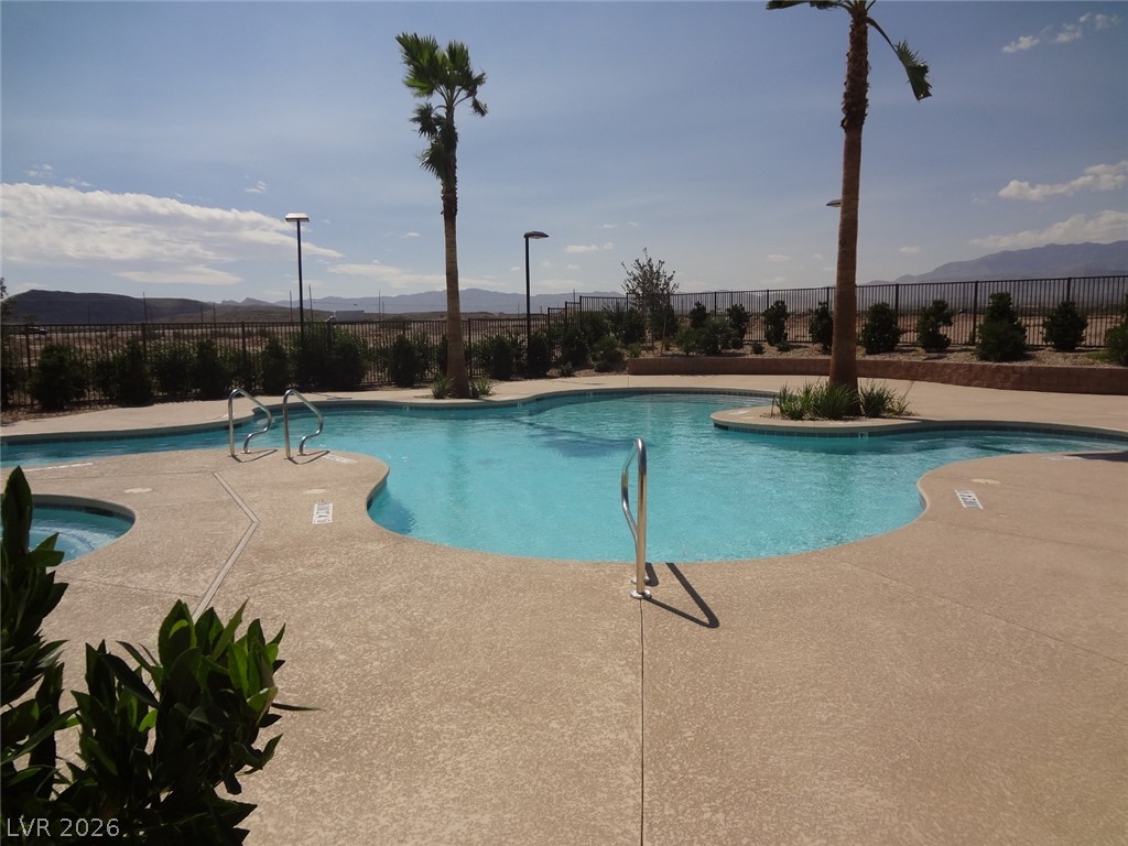 9453 Alma Ridge Avenue Las Vegas, NV 89178 - Photo 21 of 25 An inviting pool area with palms and mountain views, perfect for desert relaxation.