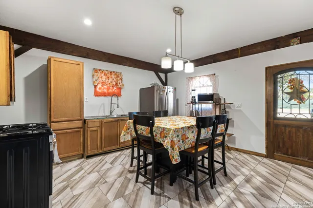 a kitchen with stainless steel appliances granite countertop a dining table chairs and granite counter tops