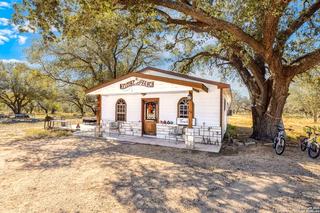 a front view of house with yard and trees around