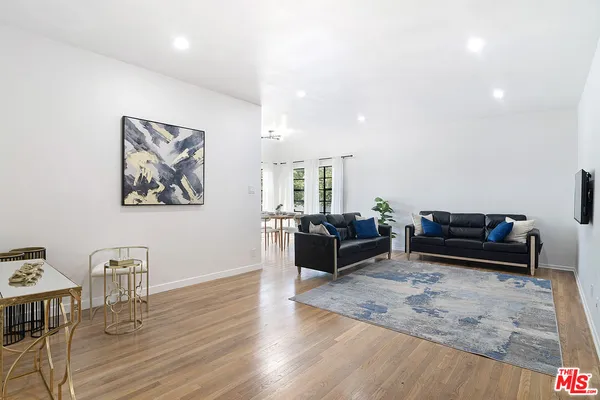 a living room with furniture wooden floor and a table