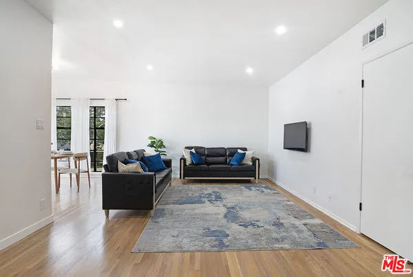 a living room with furniture and a wooden floor