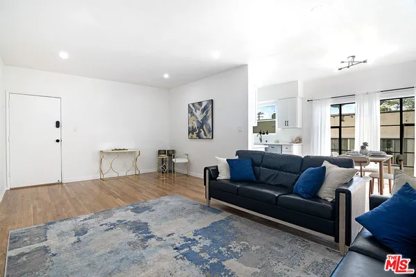 a kitchen with stainless steel appliances a dining table and chairs