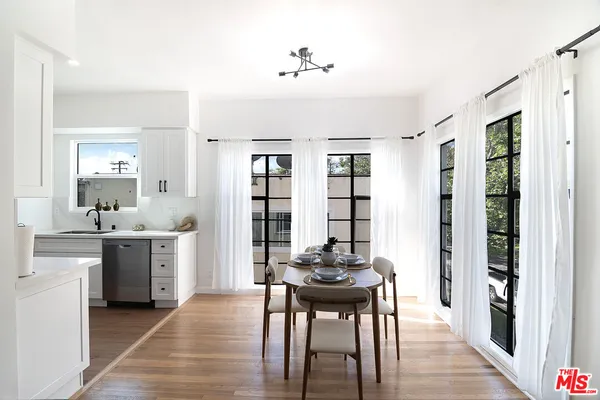 a kitchen with cabinets stainless steel appliances a sink and wooden floor