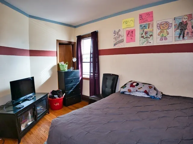 a bedroom with a bed and flat screen tv