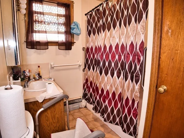 a bathroom with a sink and mirror with toilet