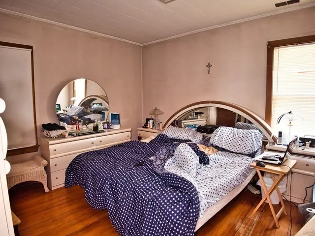 a bedroom with a bed and a window