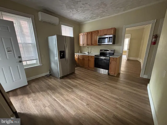 a kitchen with stainless steel appliances granite countertop a refrigerator stove and microwave