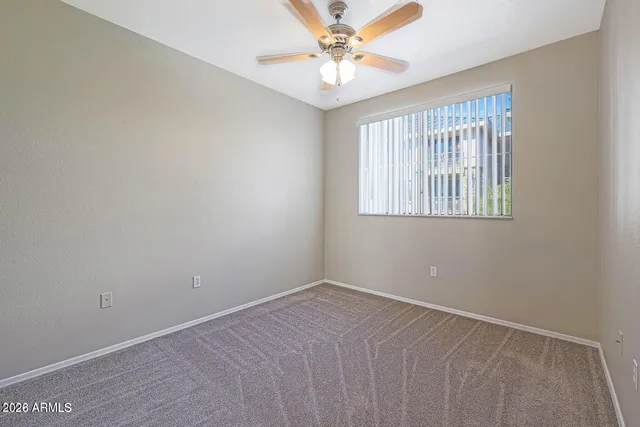 an empty room with windows and fan