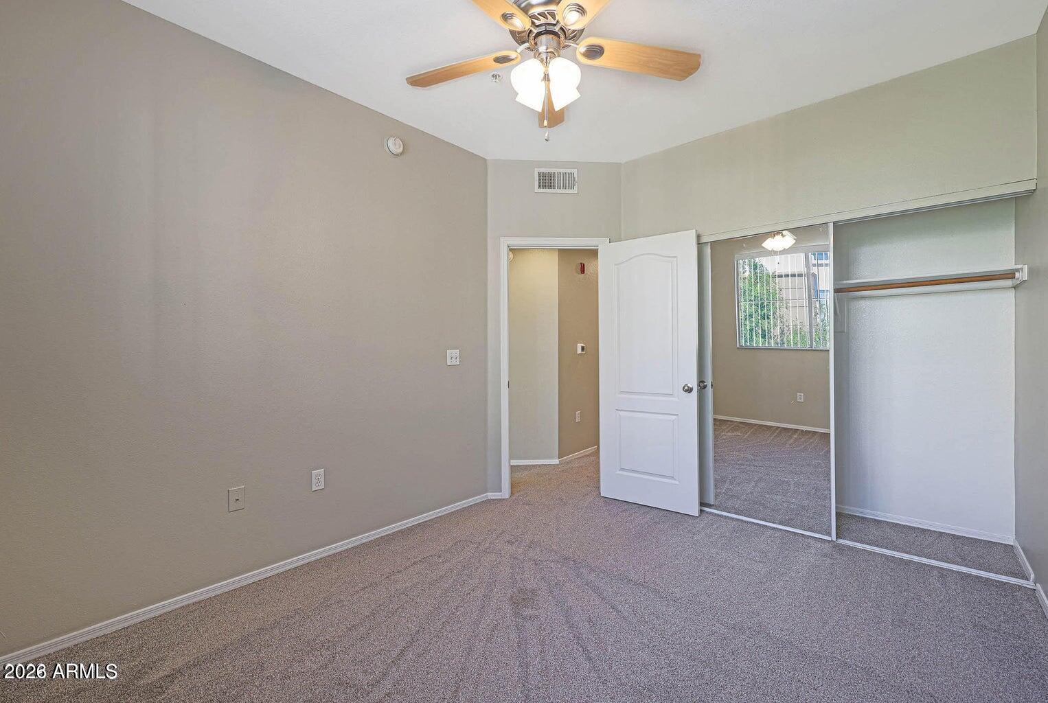 1701 East Colter Street, Unit 11 Phoenix, AZ 85016 - Photo 13 of 31 an empty room with closet and a chandelier fan
