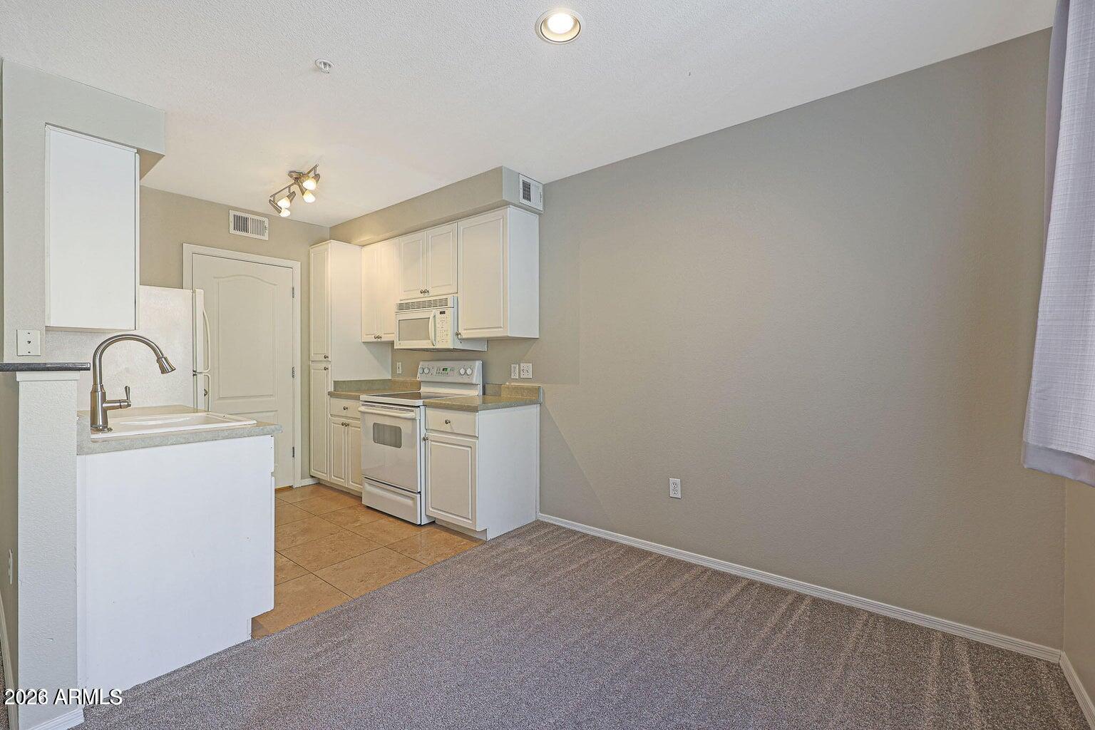 1701 East Colter Street, Unit 11 Phoenix, AZ 85016 - Photo 3 of 31 a kitchen with granite countertop white cabinets and white appliances