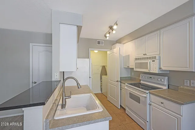 a kitchen with stainless steel appliances granite countertop a sink a stove and a refrigerator