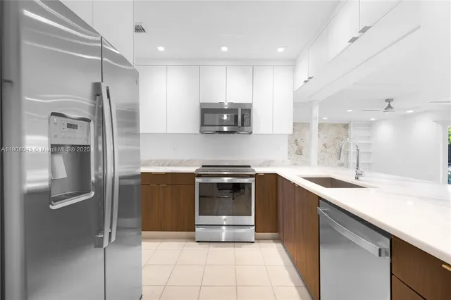 a kitchen with stainless steel appliances granite countertop a refrigerator and a sink