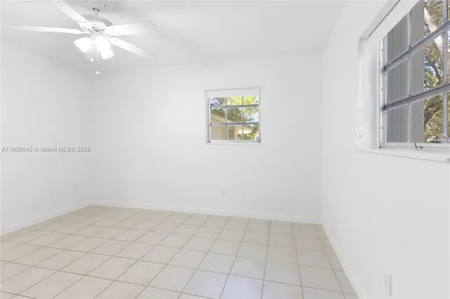 an empty room with a window and a fan