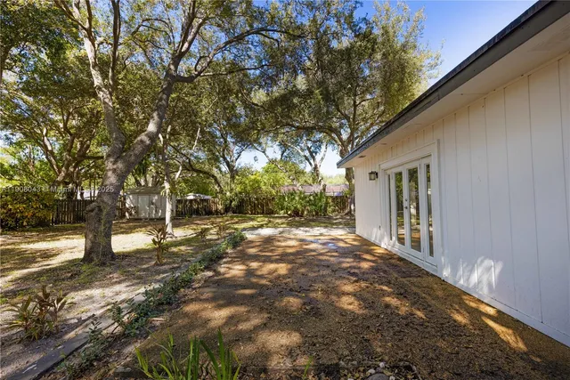 a view of a yard with plants and trees