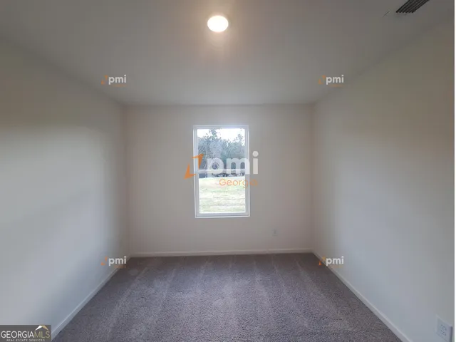 an empty room with a window and a bathroom