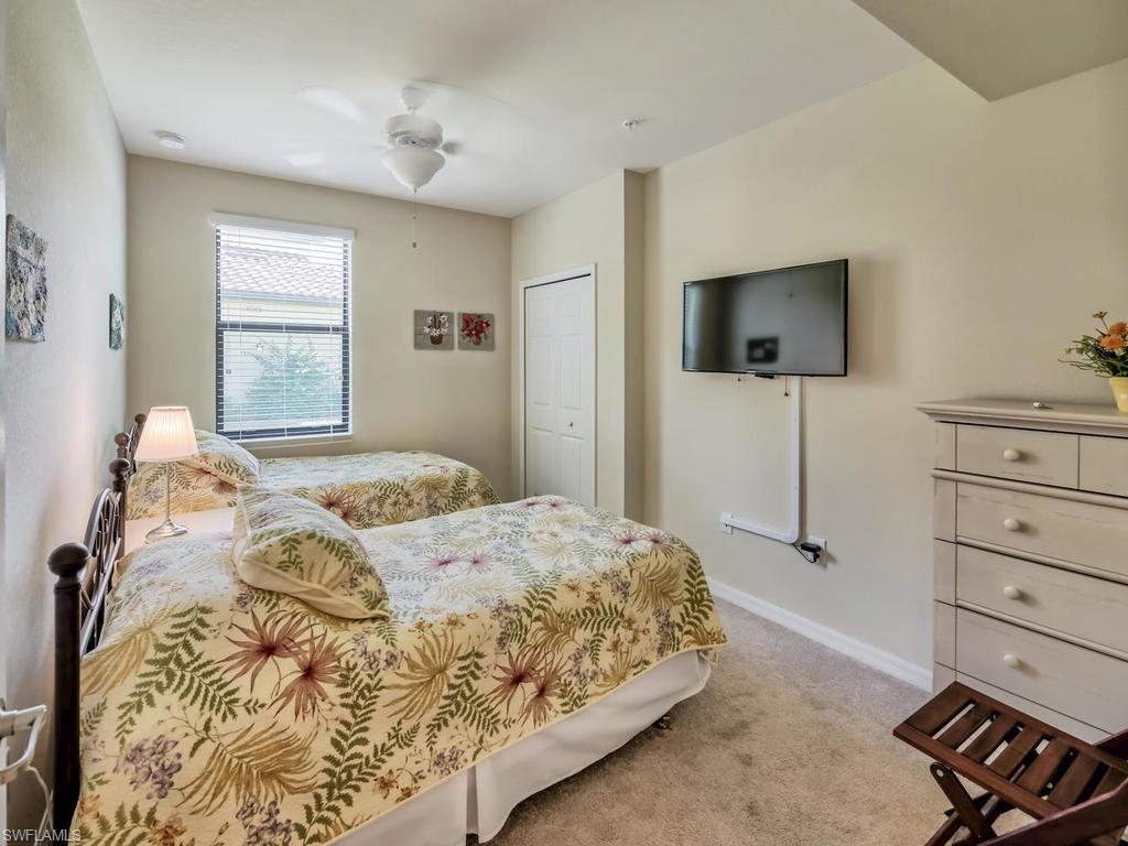 9114 Prima Way, Unit 102 Naples, FL 34113 - Photo 17 of 33 a bedroom with a bed and a flat screen tv
