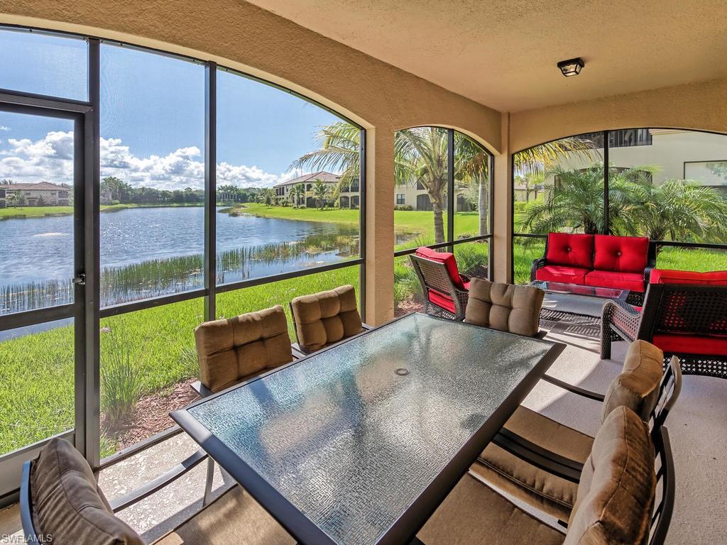 9114 Prima Way, Unit 102 Naples, FL 34113 - Photo 20 of 33 a living room with a floor to ceiling window and couch