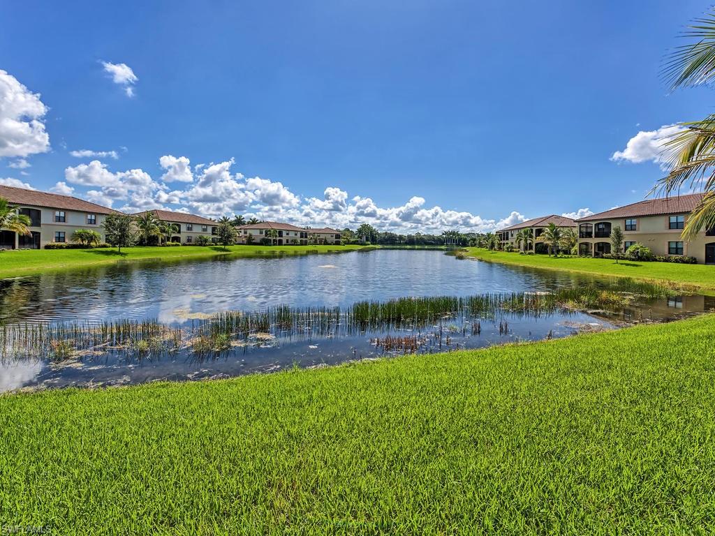 9114 Prima Way, Unit 102 Naples, FL 34113 - Photo 21 of 33 a view of a lake with houses in the back