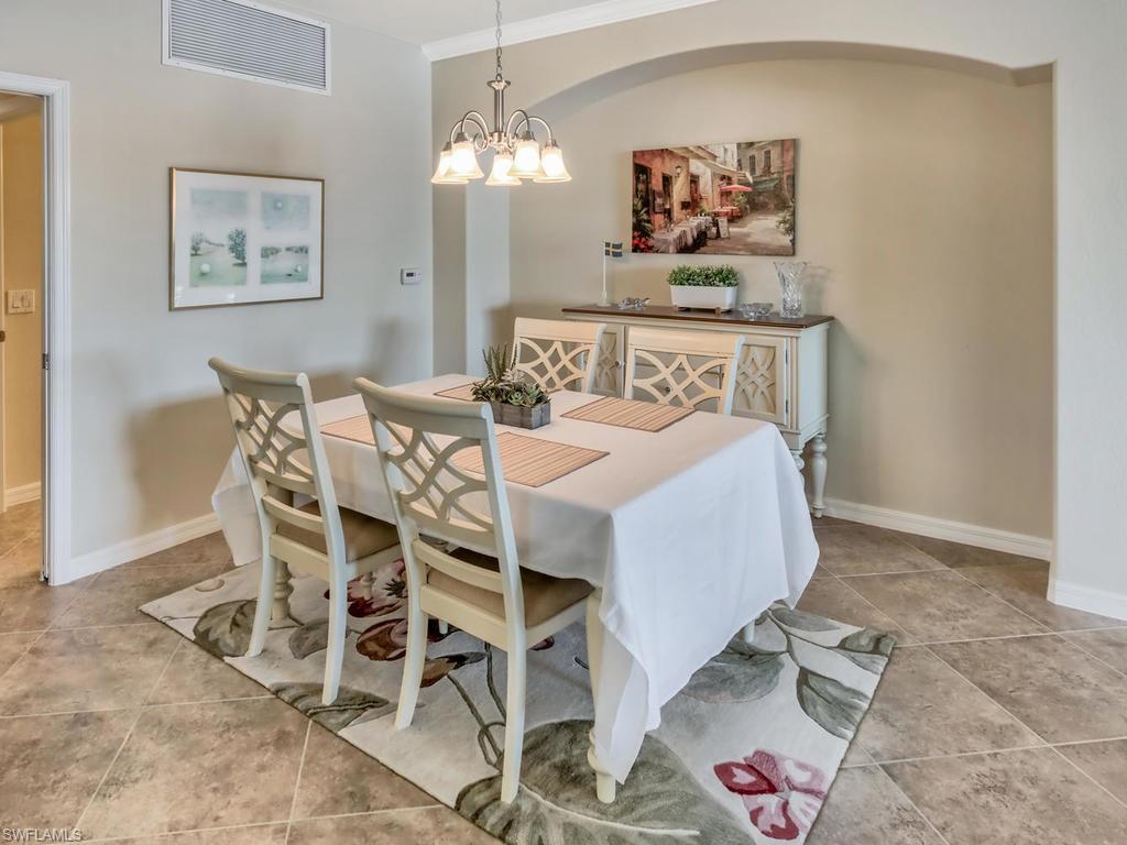 9114 Prima Way, Unit 102 Naples, FL 34113 - Photo 6 of 33 a bedroom with a bed and a table with table