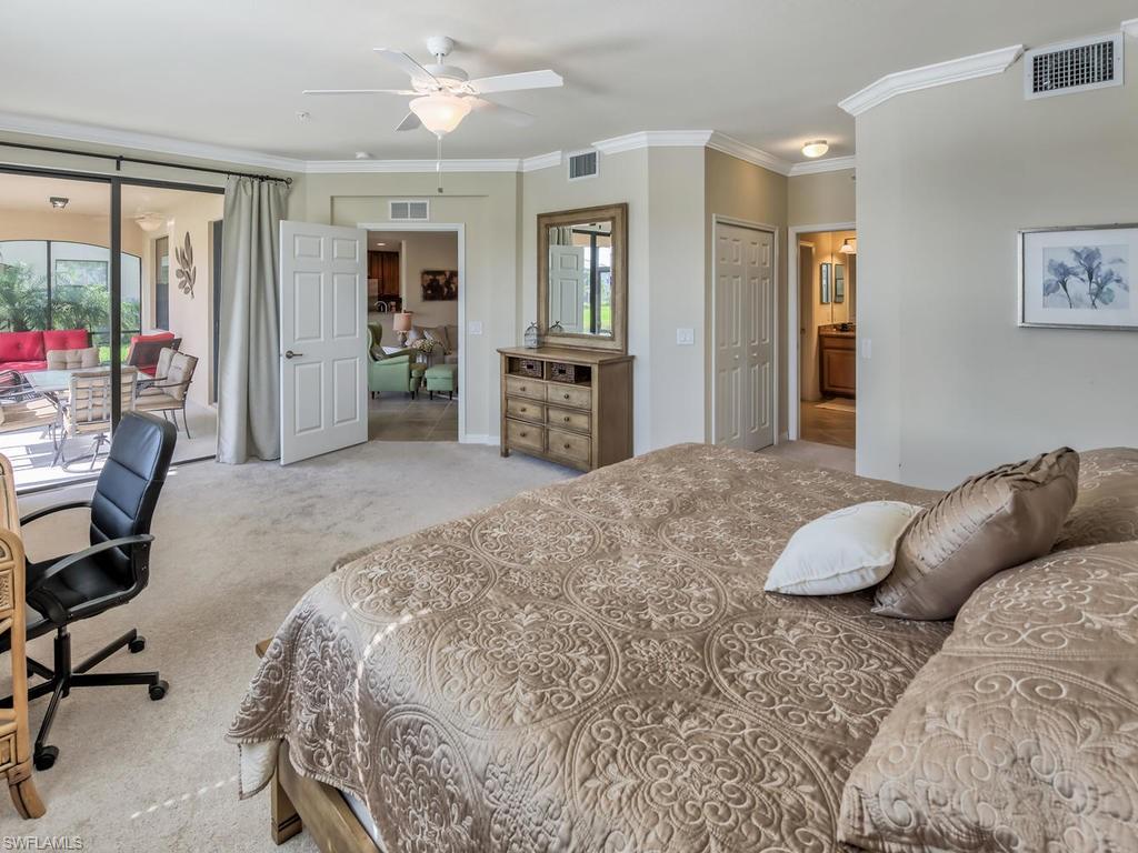 9114 Prima Way, Unit 102 Naples, FL 34113 - Photo 10 of 33 a bedroom with a large bed and a large window