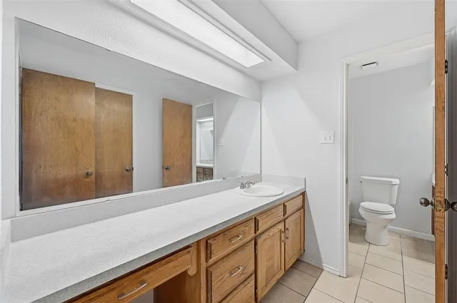 a bathroom with a sink a toilet and a mirror