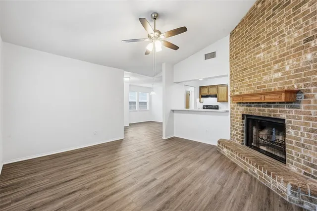 wooden floor fireplace and windows in an empty room