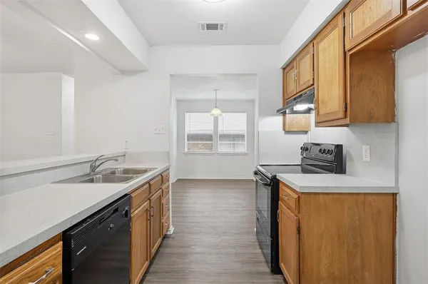 a kitchen with a sink a stove and cabinets