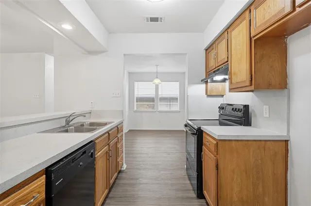 a kitchen with a sink a stove and cabinets
