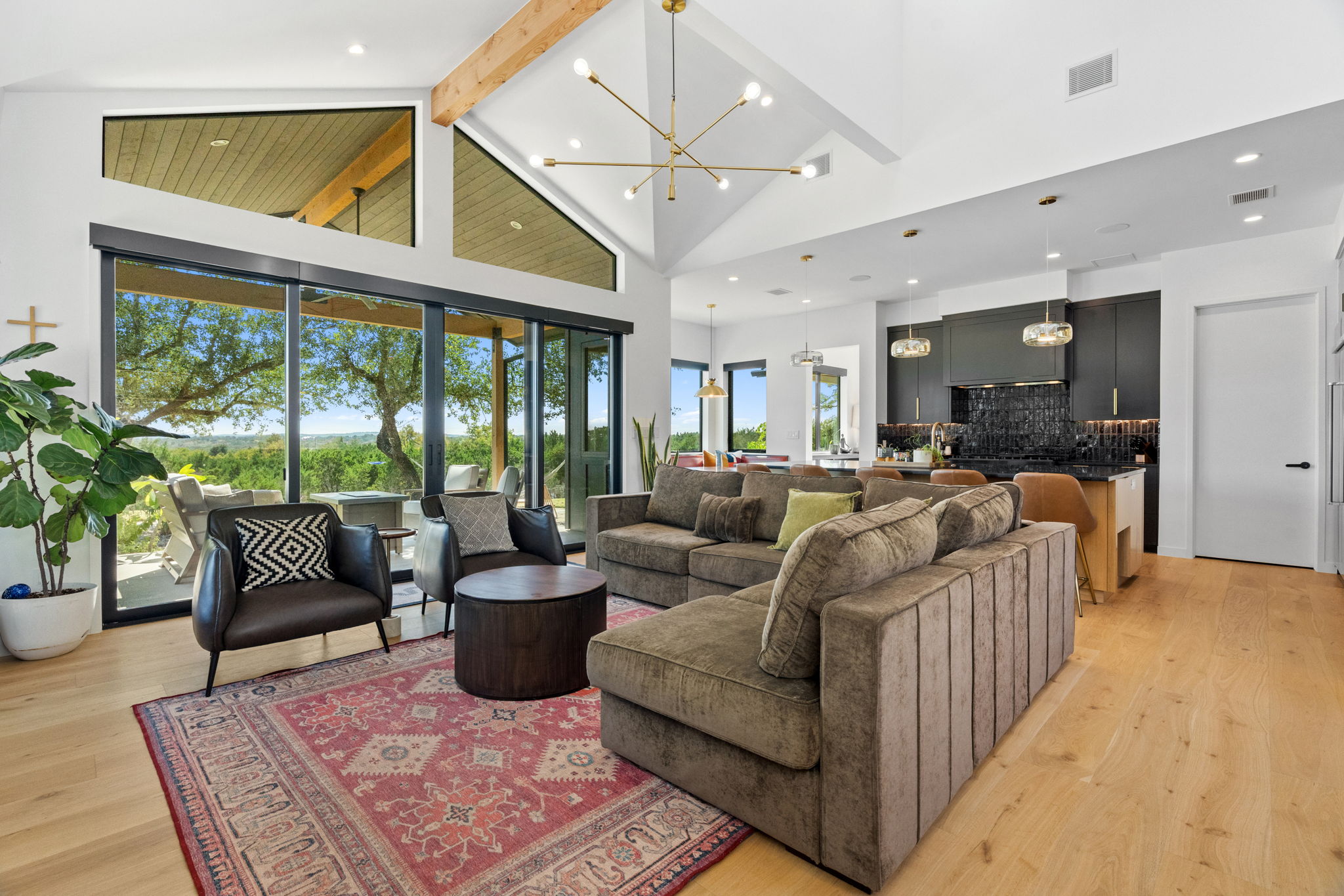 503 Happy Trail Dripping Springs, TX 78620 - Photo 1 of 38 Open-concept living space with vaulted ceilings featuring exposed wood beams and light wood-finish flooring
