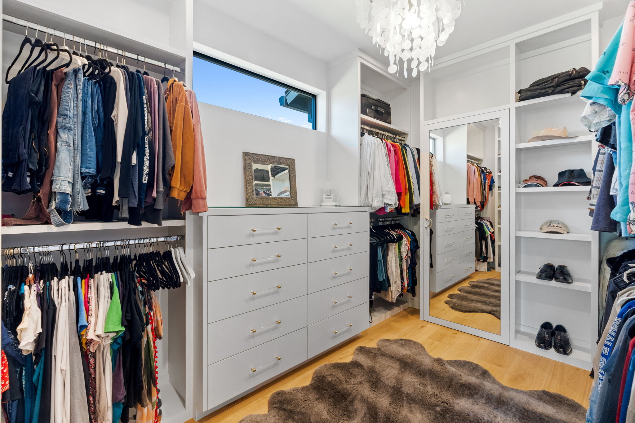 503 Happy Trail Dripping Springs, TX 78620 - Photo 18 of 38 Custom closet system featuring extensive shelving, hanging rods, built-in drawer storage, hardwood-style flooring, and a full-length mirror