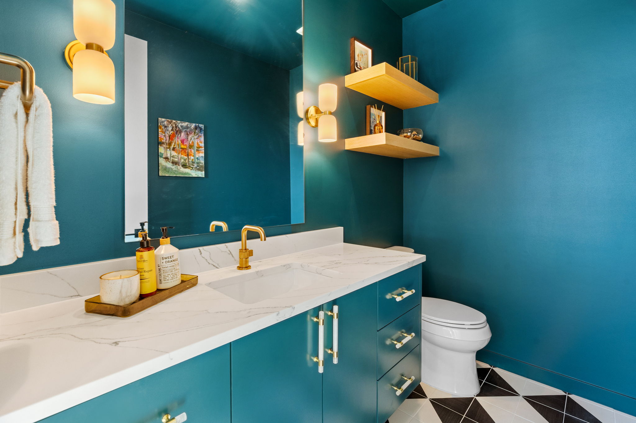 503 Happy Trail Dripping Springs, TX 78620 - Photo 19 of 38 Bathroom vanity featuring a white countertop with integrated sink, gold-finish faucet, and teal cabinetry with gold-finish hardware