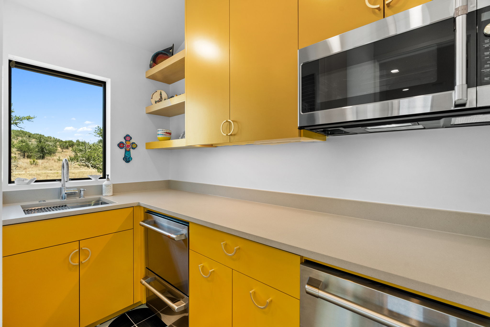 503 Happy Trail Dripping Springs, TX 78620 - Photo 30 of 38 Kitchenette with vibrant yellow cabinetry, light-toned countertops, and a stainless steel under-mount sink