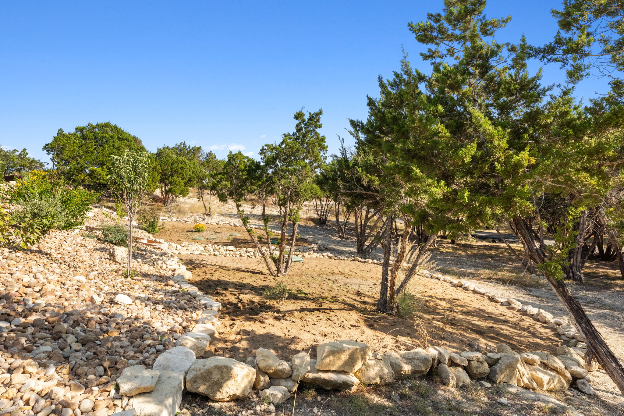 503 Happy Trail Dripping Springs, TX 78620 - Photo 37 of 38 Expansive natural landscape featuring native trees, established low-lying vegetation, and a clear blue sky