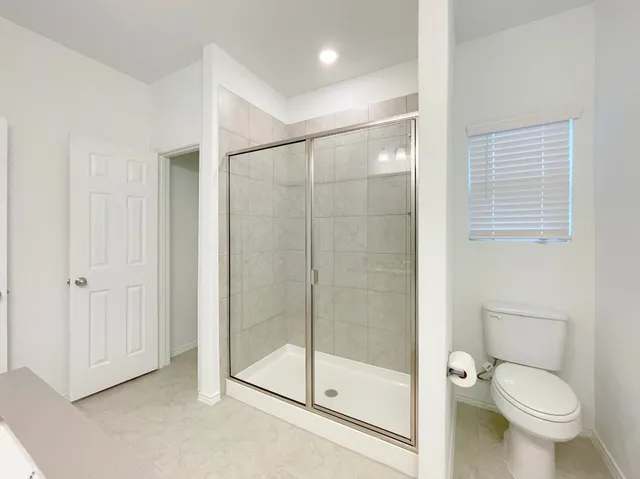 a bathroom with a shower a toilet and a sink