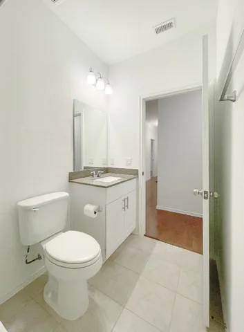 a spacious bathroom with a toilet a sink a mirror and a shower