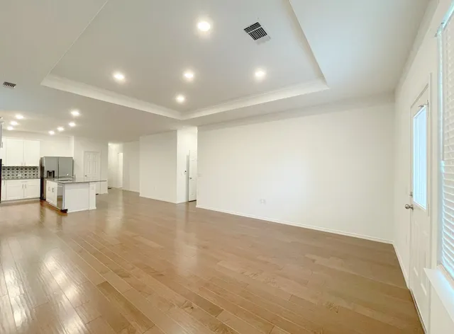 a view of empty room with wooden floor
