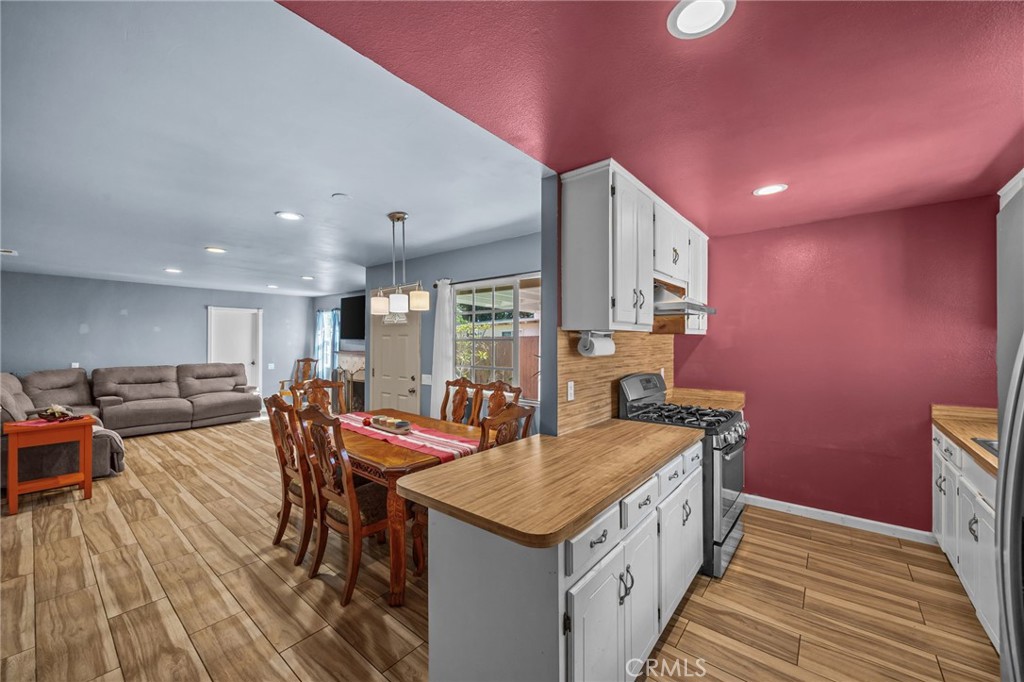 820 Cozy Court Fallbrook, CA 92028 - Photo 11 of 38 a kitchen with stainless steel appliances granite countertop a kitchen island a stove a sink a dining table and chairs with wooden floor