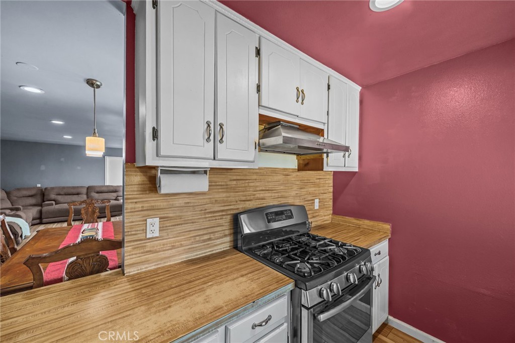 820 Cozy Court Fallbrook, CA 92028 - Photo 16 of 38 a kitchen with granite countertop a stove and white cabinets