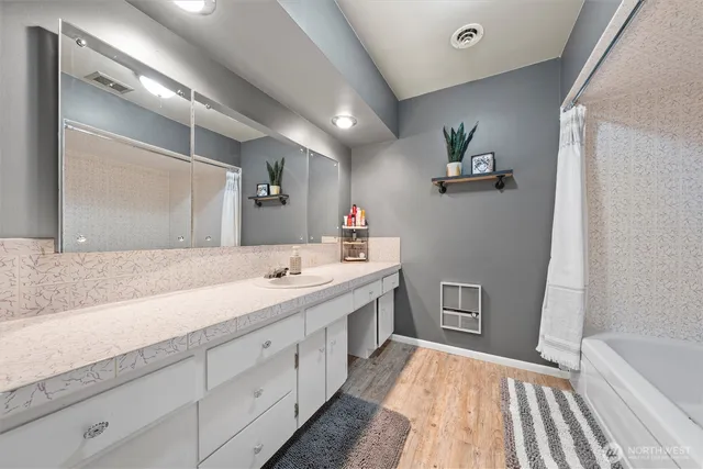 a spacious bathroom with a sink a mirror and a bathtub