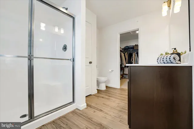 a view of a hallway with wooden floor and closet