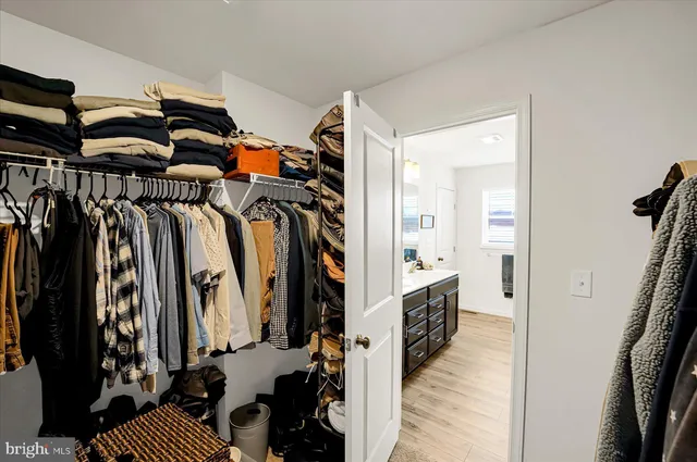 a view of walk in closet with clothes and shoes