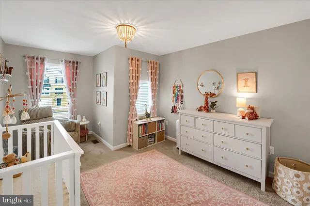 a bedroom with a baby bed dresser and a window