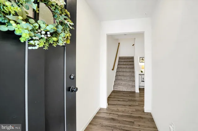 a view of a hallway with wooden floor and a potted plant