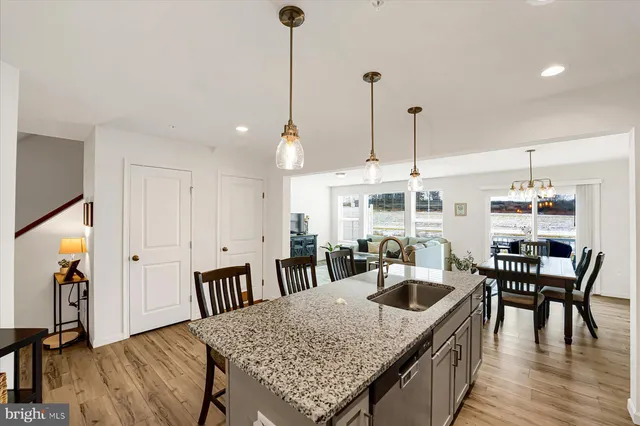 a kitchen with a table chairs and wooden floors
