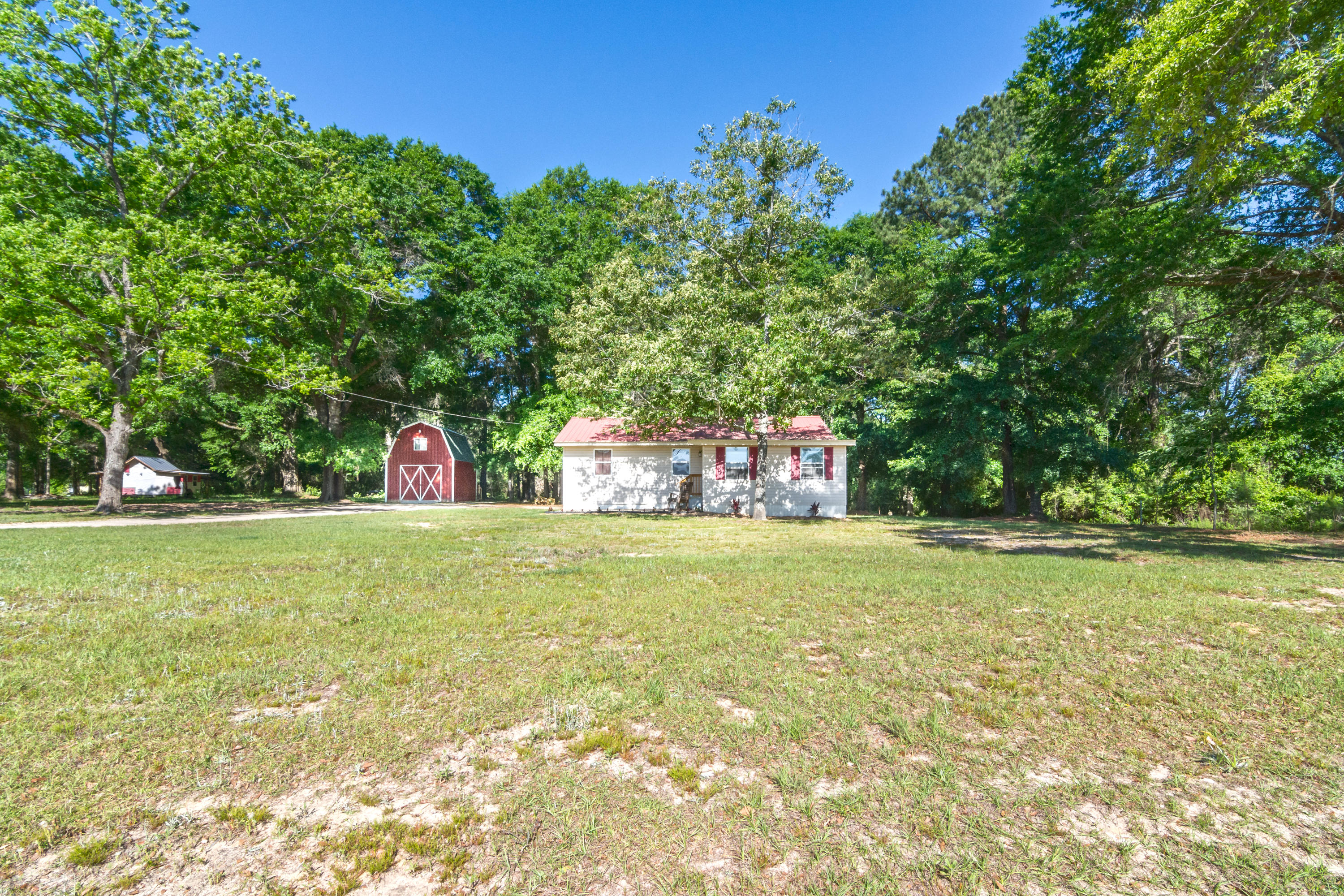 8322 Stokes Road Laurel Hill, FL 32567 - Photo 3 of 25 a front view of a house with a yard and a large tree