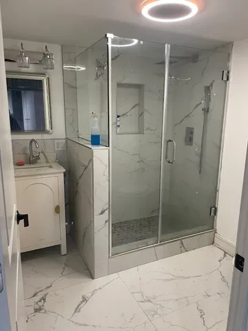 a bathroom with a shower sink and mirror