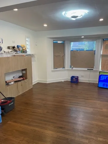a view of a and an empty room with kitchen and window